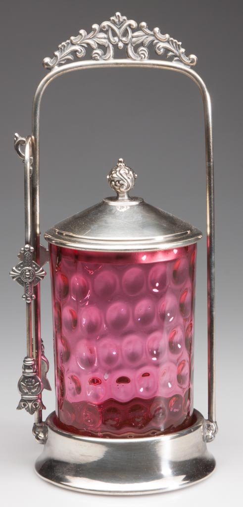 SPOT-OPTIC PICKLE CASTER: SPOT-OPTIC PICKLE CASTER, cranberry, jar with factory polished rim. Fitted in a quadruple-plate frame marked for Poole Silver Co., with tongs. Late 19th/early 20th century. 10 1/2" HOA. Circa:Late 19t