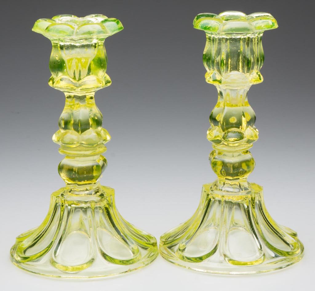 PRESSED PETAL AND LOOP CANDLESTICKS, NEAR PAIR: PRESSED PETAL AND LOOP CANDLESTICKS, NEAR PAIR, canary yellow, each six-petal socket with a hexagonal extension, raised on a hexagonal knop and seven-loop circular base with rough pontil mark, wafer c