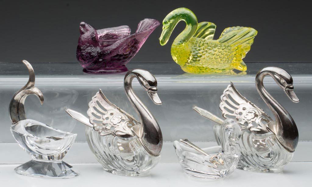 ASSORTED FIGURAL GLASS OPEN SALTS, LOT OF SIX: ASSORTED FIGURAL GLASS OPEN SALTS, LOT OF SIX, including a crystal example with .835 silver fishtail and spoon, and a pair of Swans with movable wings, mounts marked Italy. 20th century. 1 5/8" to 3 1