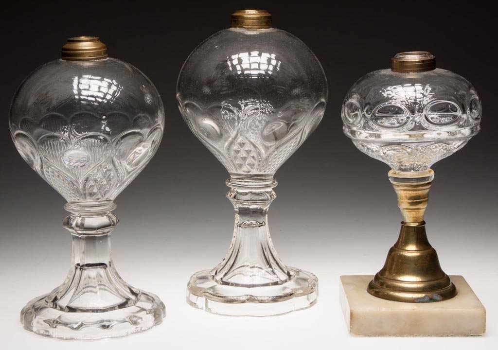 VARIOUS PATTERN STAND LAMPS, LOT OF THREE: VARIOUS PATTERN STAND LAMPS, LOT OF THREE, colorless fonts, comprising two Hearts Under Glass examples and a Ring Punty, Sawtooth Eye and Leaf example with brass stem and marble base, Period No. 1 col