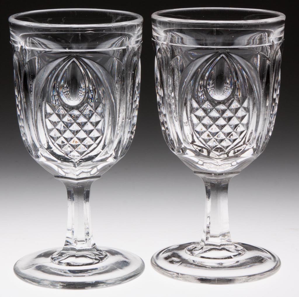 NEW ENGLAND PINEAPPLE CHAMPAGNE GLASSES, LOT OF TWO: NEW ENGLAND PINEAPPLE CHAMPAGNE GLASSES, LOT OF TWO, colorless lead glass. Third quarter 19th century. 5" H. Provenance: Lillian "Lil" and Walter "Bud" Marchant Collection/Lil-Bud Antiques.