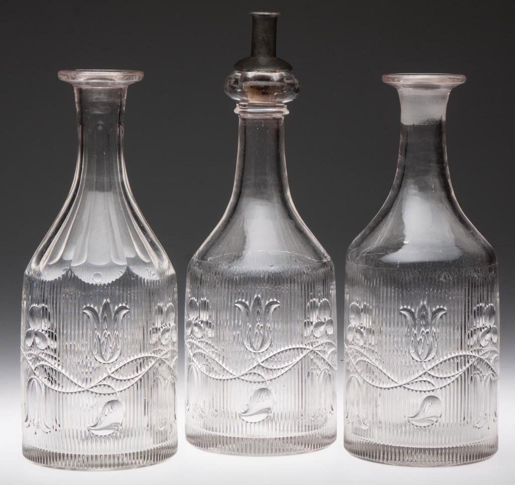 BELLFLOWER - DOUBLE VINE QUART DECANTERS, LOT OF THREE: BELLFLOWER - DOUBLE VINE QUART DECANTERS, LOT OF THREE, colorless lead glass, each with vines flowing in opposing directions, two with ribs ending in scallops at shoulder, the other with eight cut flu