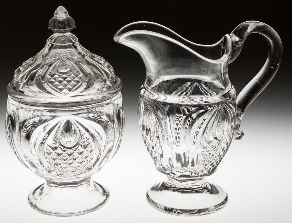 NEW ENGLAND PINEAPPLE TABLE ARTICLES, LOT OF TWO: NEW ENGLAND PINEAPPLE TABLE ARTICLES, LOT OF TWO, colorless lead glass, comprising a creamer with applied handle and a covered sugar. Boston and Sandwich Glass Co., and probably others. Third quarter 