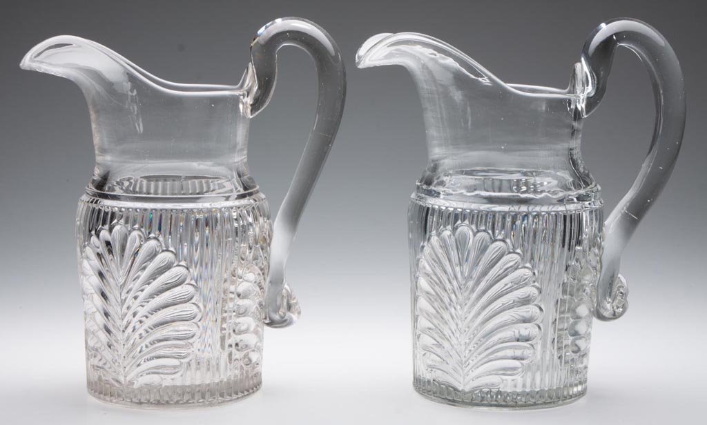 RIBBED PALM / SPRIG (OMN) WATER PITCHERS, LOT OF TWO: RIBBED PALM / SPRIG (OMN) WATER PITCHERS, LOT OF TWO, colorless lead glass, each with applied handle. M'Kee & Brothers. Third quarter 19th century. 9 1/4" HOA. Provenance: Lillian "Lil" and Walter "Bu