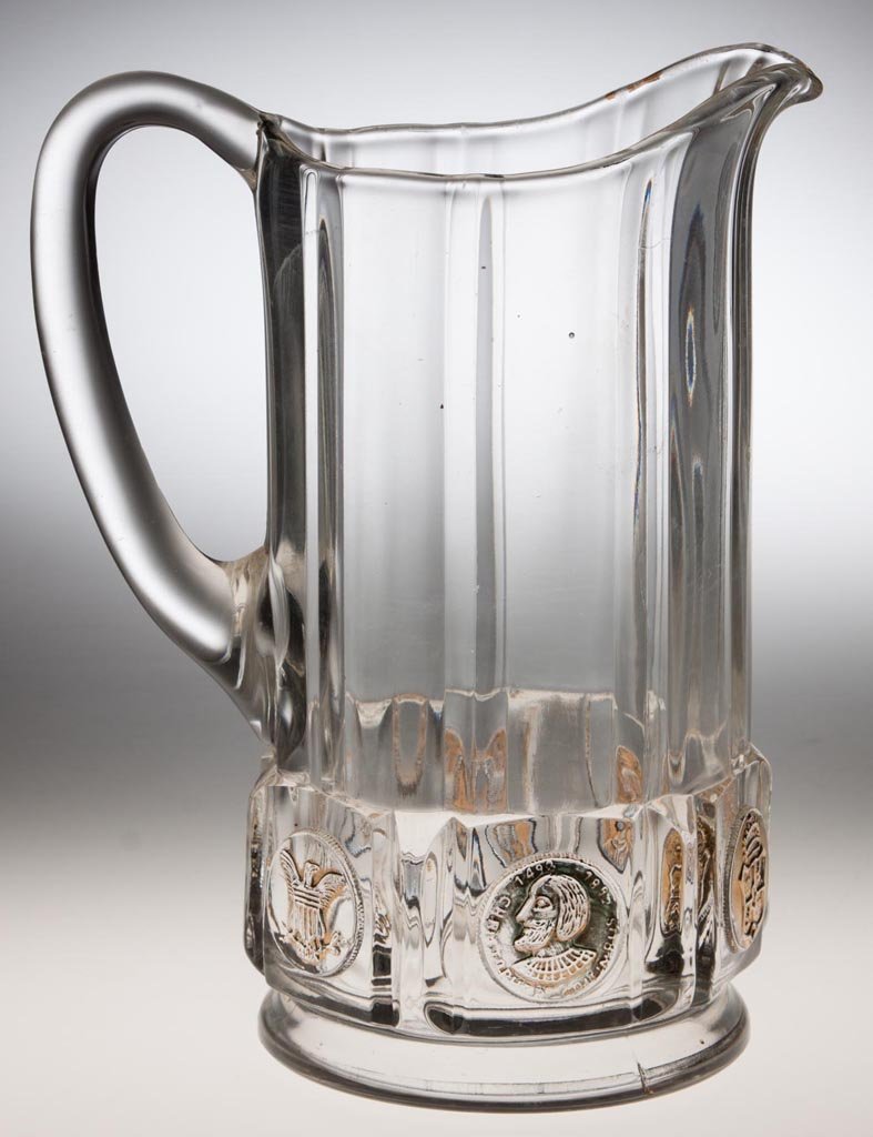 COLOMBIAN COIN WATER PITCHER: COLOMBIAN COIN WATER PITCHER, colorless with gilt decoration. Central Glass Co. Late 19th/early 20th century. 8 1/2" HOA, 4 1/4" D base. Provenance: From the collection of the late Betty Jane Renn, Su