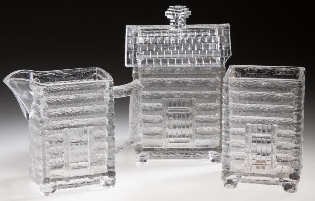 LOG CABIN THREE-PIECE TABLE SET: LOG CABIN THREE-PIECE TABLE SET, colorless, comprising a creamer, covered sugar, and a spooner. Central Glass Co. Fourth quarter 19th century. Literature: Hallock - Central Glass Company, p. 154. Prov