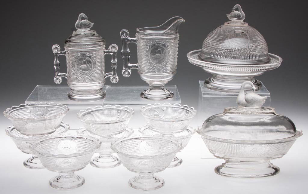 SWAN / NETTED SWAN TABLE ARTICLES, LOT OF 12: SWAN / NETTED SWAN TABLE ARTICLES, LOT OF 12, colorless, comprising an oval covered dish, a covered pickle/marmalade jar, covered butter, creamer and eight footed sauces. Fourth quarter 19th century.
