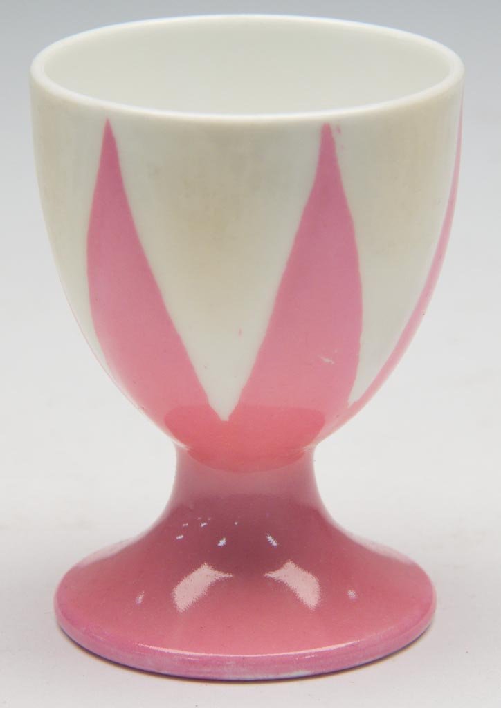 ENGLISH PORCELAIN SHELLEY CHINA LTD. "PINK STAR" PATTER: ENGLISH PORCELAIN SHELLEY CHINA LTD. "PINK STAR" PATTERN "DAINTY" SHAPE EGG CUP ON CYLINDRICAL FOOT, the ridged sides painted an off-white color, the molded star, ankle and foot painted pink. Printed 