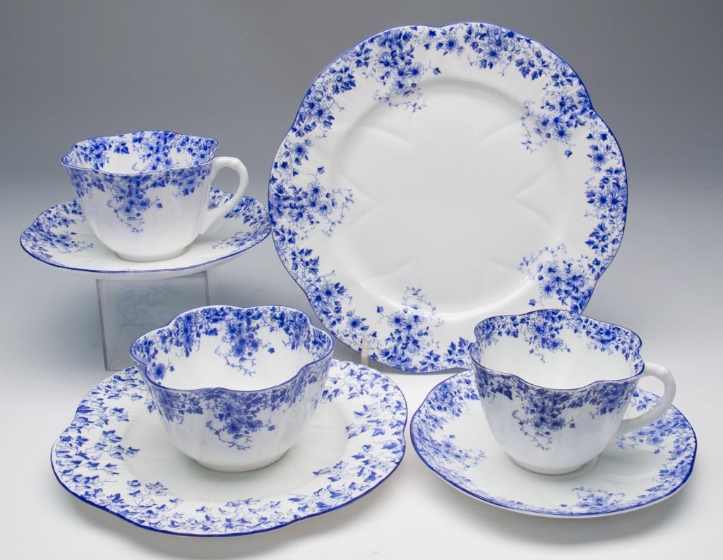 ENGLISH PORCELAIN SHELLEY CHINA LTD. ARTICLES, LOT OF S: ENGLISH PORCELAIN SHELLEY CHINA LTD. ARTICLES, LOT OF SEVEN "DAINTY BLUE" PATTERN "DAINTY" SHAPE TRIO, ANOTHER TRIO, AND A SUGAR BOWL, the scallop-molded dinnerware printed with the blue scrolling flo