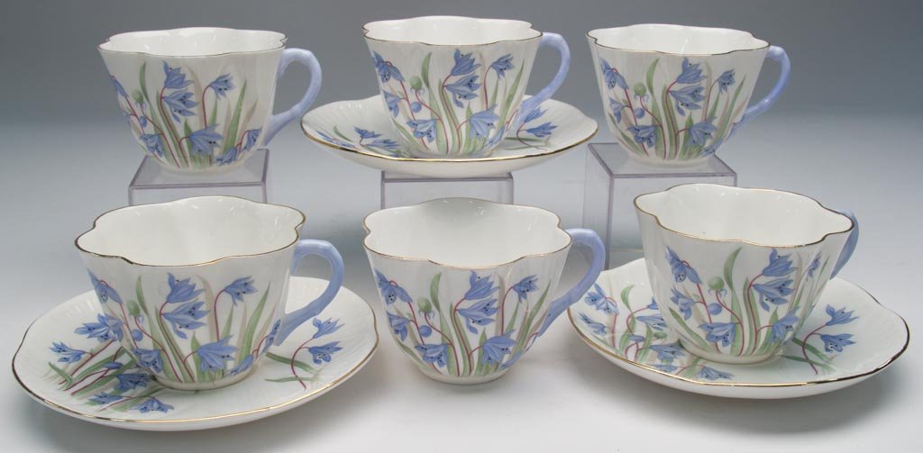 ENGLISH PORCELAIN SHELLEY CHINA LTD. "SCILLA" PATTERN ": ENGLISH PORCELAIN SHELLEY CHINA LTD. "SCILLA" PATTERN "DAINTY" SHAPE TABLEWARE ARTICLES, LOT OF NINE, including six cups and three saucers. All with the blue floral print under gilt line rims, with pr