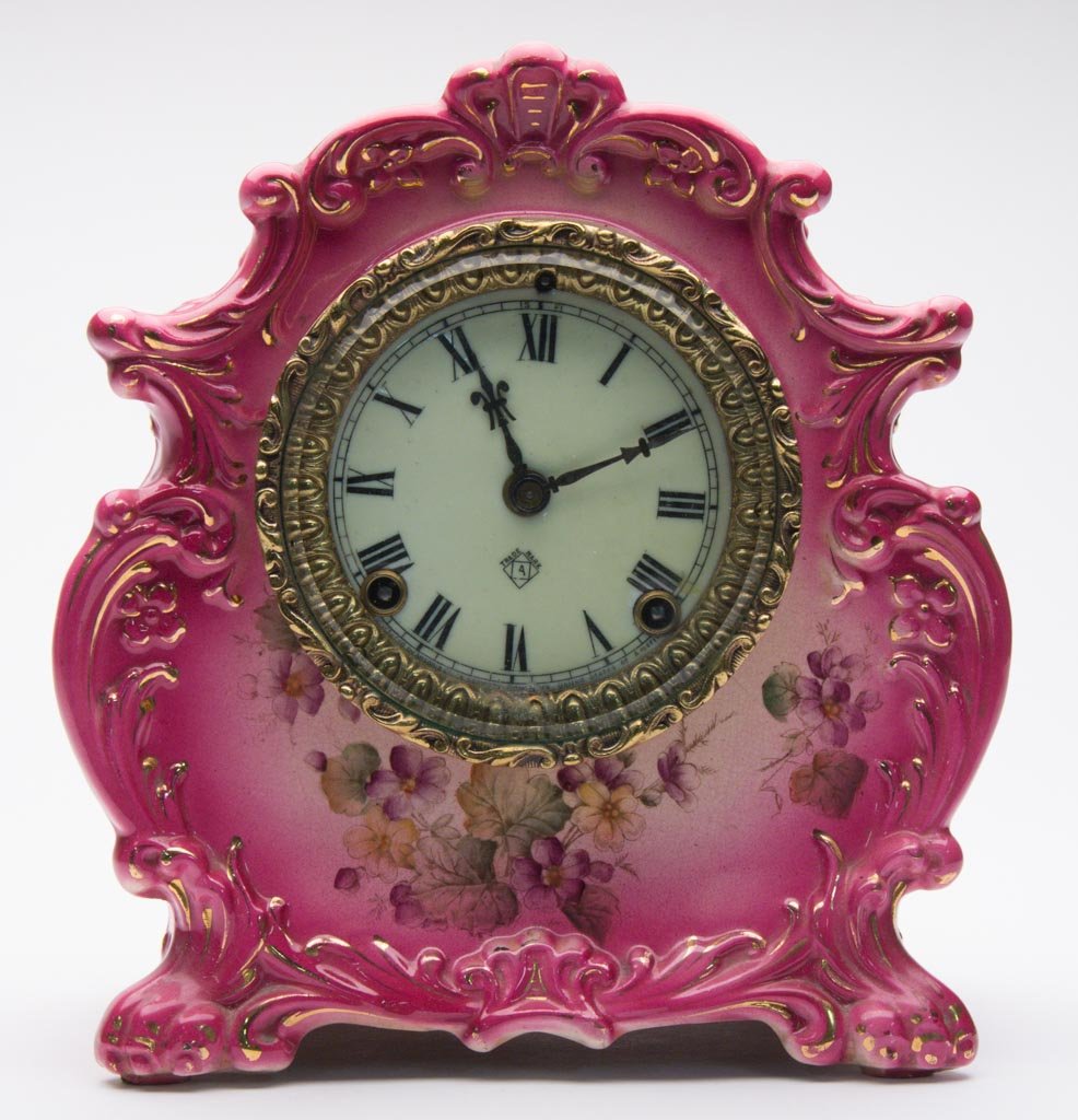 GERMAN POTTERY ROYAL BONN-TYPE CASED ANSONIA: GERMAN POTTERY ROYAL BONN-TYPE CASED ANSONIA MANTEL CLOCK, "TEXT" MODEL, the clock of swollen, ogee shape, with scroll-molding to sides and crest, on four feet, the center and sides printed and over-e