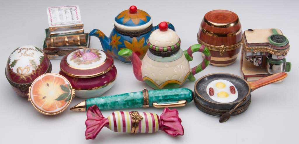 FRENCH PORCELAIN LIMOGES HAND-PAINTED LIMITED EDITION P: FRENCH PORCELAIN LIMOGES HAND-PAINTED LIMITED EDITION PILL AND MEMENTO BOXES, with gold and brass frames, the bodies formed as a frying pan; barrel; coffee maker; candy; pen; citron half; stack of boo