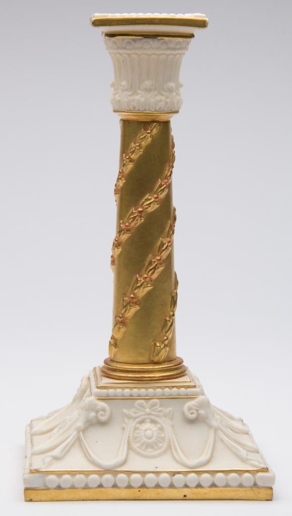 ENGLISH CHINA ROYAL WORCESTER IVORY-WARE CANDLESTICK: ENGLISH CHINA ROYAL WORCESTER IVORY-WARE CANDLESTICK, modeled as a neo-classical pillar with square bobeche and flaring square base, the central pillar molded with a twining laurel wreath descending f