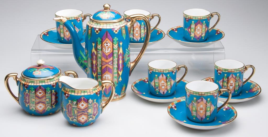 ART DECO JAPANESE PORCELAIN NORITAKE DEMITASSE SET, NEO: ART DECO JAPANESE PORCELAIN NORITAKE DEMITASSE SET, NEO-EGYPTIAN AND NATIVE AMERICAN-STYLE MOTIFS, the ovoid shapes with gilt rims and turquoise blue grounds, all hand-painted with geometric stylized 