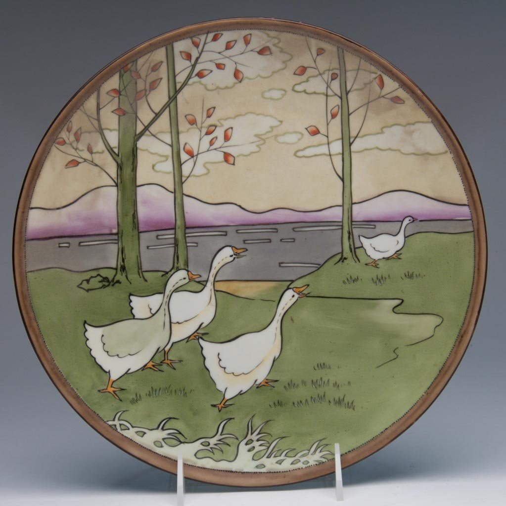 JAPANESE PORCELAIN NIPPON PLAQUE, "WALKING GEESE": JAPANESE PORCELAIN NIPPON PLAQUE, "WALKING GEESE", the gilt band to rim enclosing a band of tiny raised black enamel dots, enclosing a vibrant image of geese walking in a watery landscape under the sh