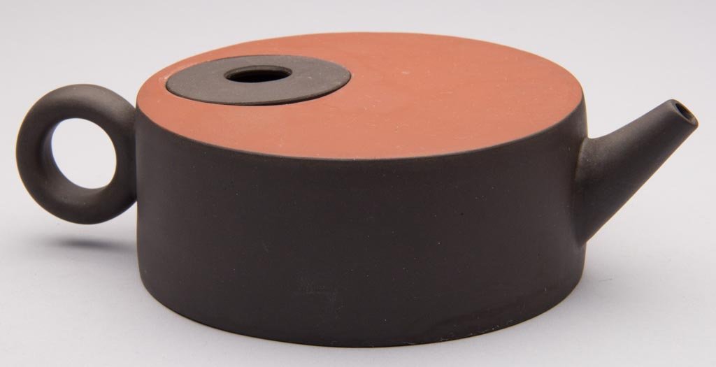 CHINESE YIXING ZISHA CLAY ARTISTIC RED AND BROWN FLAT-T: CHINESE YIXING ZISHA CLAY ARTISTIC RED AND BROWN FLAT-TOPPED STRAIGHT-CYLINDRICAL TEAPOT, with a hole in the center of the inset cover, set into the teapot top. The ring handle and straight spout in b