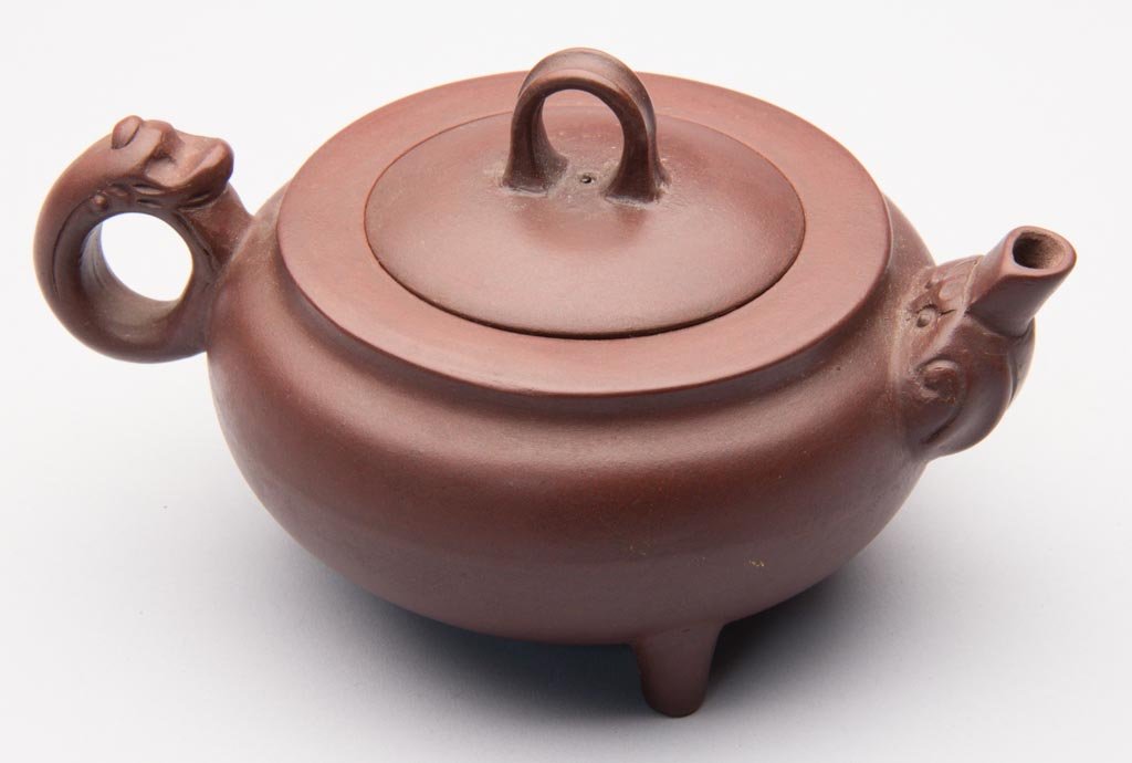 CHINESE YIXING ZISHA CLAY ARTISTIC POLISHED BROWN TEAPO: CHINESE YIXING ZISHA CLAY ARTISTIC POLISHED BROWN TEAPOT BY ZHOU GUIZHEN (B. 1943), on three pedestal feet, the squat globular pot with animal-type top to ring handle, a strap-form knop to the cover, 