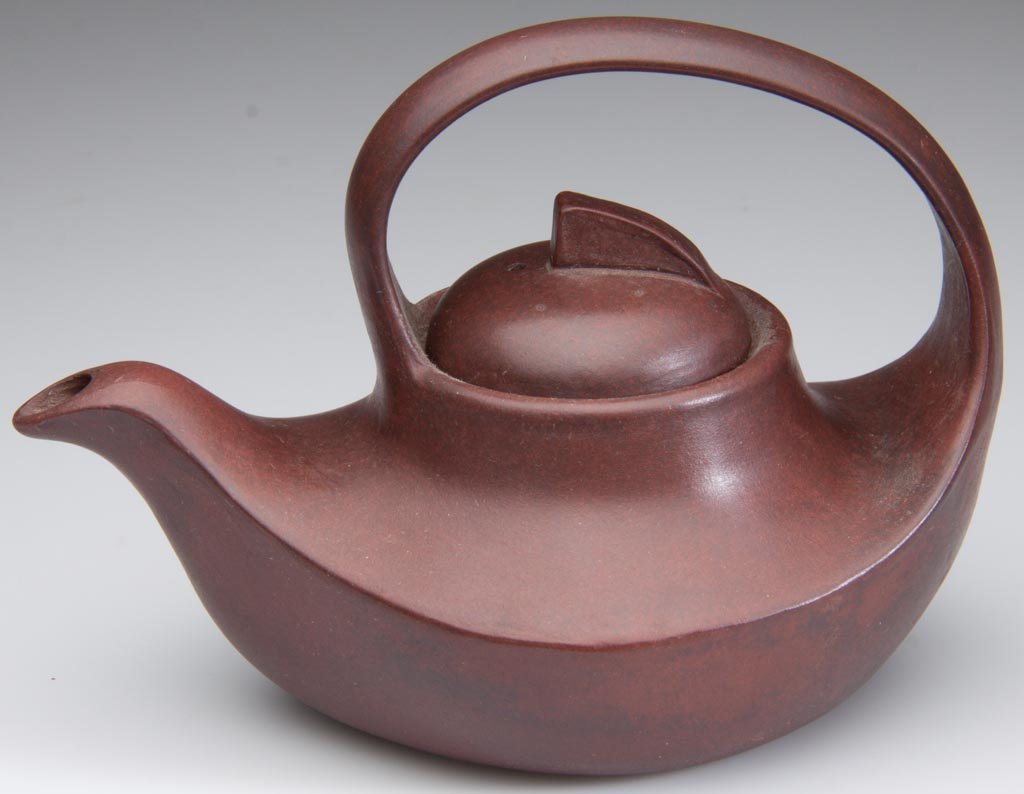 CHINESE JIANGSU YIXING ZISHA CLAY FACTORY ARTISTIC POLI: CHINESE JIANGSU YIXING ZISHA CLAY FACTORY ARTISTIC POLISHED CLAY "FLOWING" DARK-BROWN TEAPOT AND COVER, the body of low, ovate form creating a graceful curve, the handle arcing over the top, the spout