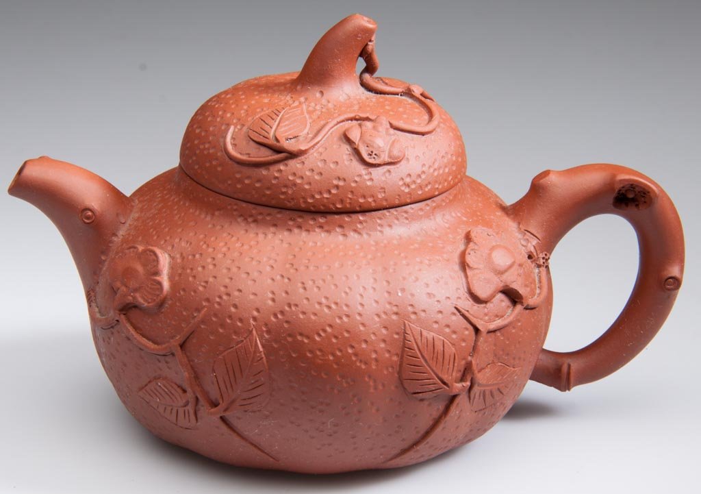 CHINESE YIXING ZISHA CLAY ARTISTIC RED TEAPOT AND COVER: CHINESE YIXING ZISHA CLAY ARTISTIC RED TEAPOT AND COVER, the body formed as a low, globular pimple-surfaced gourd with crabstock handle and incurvate, root-form spout, the domed cover with stem-form k
