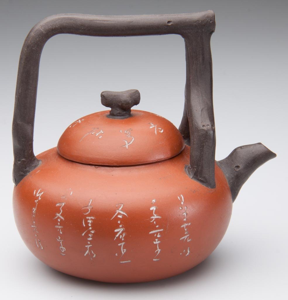 CHINESE YIXING ZISHA CLAY ARTISTIC RED AND BROWN TEAPOT: CHINESE YIXING ZISHA CLAY ARTISTIC RED AND BROWN TEAPOT AND COVER, the globular body with domed cover and twig-form knop, spout, with arcing handle over the body, the cover incised with calligraphy, i