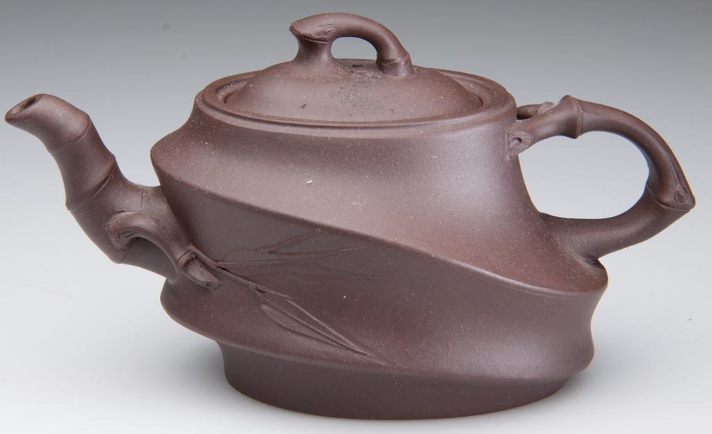 CHINESE YIXING ZISHA CLAY ARTISTIC DARK-BROWN TEAPOT AN: CHINESE YIXING ZISHA CLAY ARTISTIC DARK-BROWN TEAPOT AND COVER, formed to resemble a low, squat piece of bamboo, with crabstock handle and spout, the ovular domed cover with branch-form knop, impresse