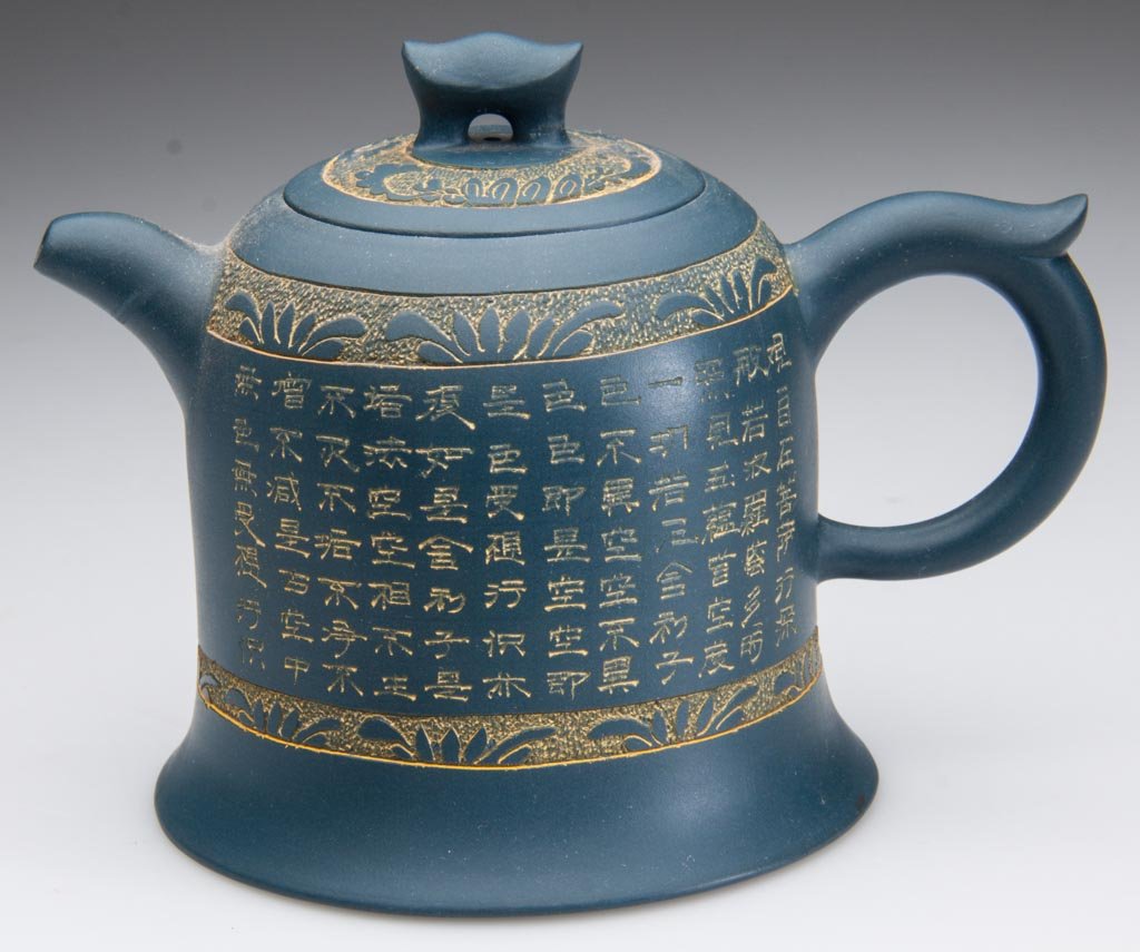 CHINESE YIXING ZISHA CLAY ARTISTIC TEAL-BLUE TEAPOT AND: CHINESE YIXING ZISHA CLAY ARTISTIC TEAL-BLUE TEAPOT AND COVER, the body molded to resemble a flaring cylindrical bell, with ring handle and everted spout, the cover with a u-form knop, incised with tw