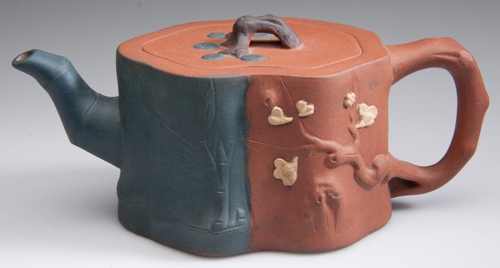CHINESE YIXING ZISHA CLAY TEAPOT AND COVER, "THREE FRIE: CHINESE YIXING ZISHA CLAY TEAPOT AND COVER, "THREE FRIENDS", one half of the body in red-brown and the other half, dark-brown, half the body formed as a prunus-tree root, with prunus tree-root handle,