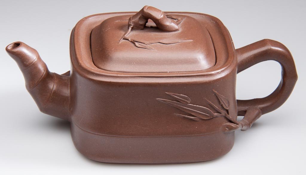 CHINESE YIXING ZISHA CLAY ARTISTIC BROWN TEAPOT AND COV: CHINESE YIXING ZISHA CLAY ARTISTIC BROWN TEAPOT AND COVER, the body of rounded square form, with faux bamboo handle and spout, "bamboo roots" molded in high-relief off the sides of both, as well as th