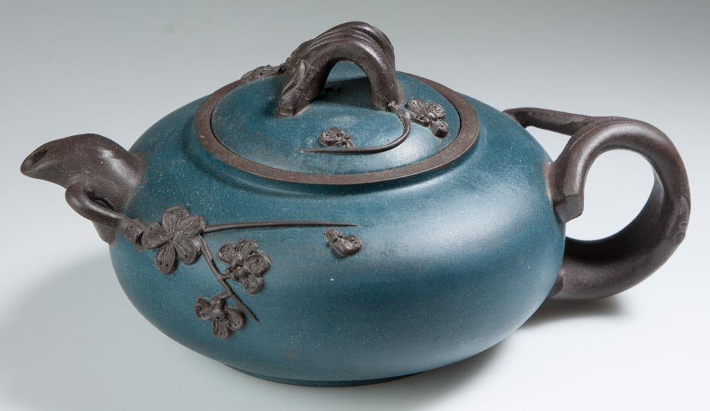 CHINESE YIXING ZISHA CLAY ARTISTIC DARK-BROWN AND TEAL-: CHINESE YIXING ZISHA CLAY ARTISTIC DARK-BROWN AND TEAL-BLUE TEAPOT AND COVER, the squat, ovular teapot with applied root handles and spout, the domed lid with root-form knop, the body and top both wit