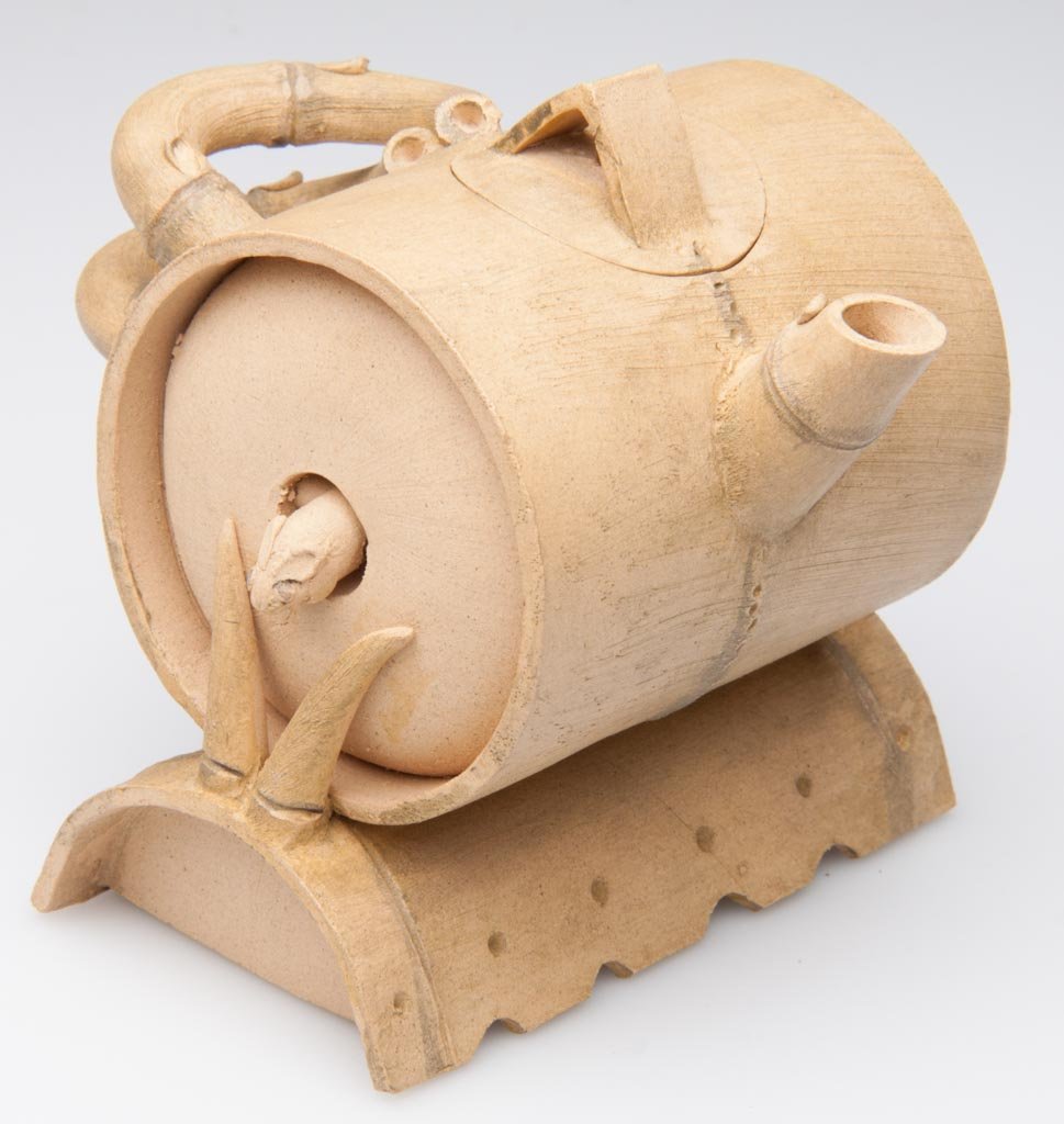 CHINESE YIXING ZISHA CLAY ARTISTIC LIGHT-BROWN TEAPOT A: CHINESE YIXING ZISHA CLAY ARTISTIC LIGHT-BROWN TEAPOT AND COVER, the body formed as a trompe l'oeil barrel at rest on another half-barrel, both barrels made to resemble bamboo, the teapot handle and s