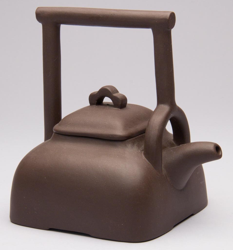 CHINESE YIXING ZISHA CLAY ARTISTIC BROWN POTTERY ROUNDE: CHINESE YIXING ZISHA CLAY ARTISTIC BROWN POTTERY ROUNDED-RECTANGULAR TEAPOT AND COVER, with tall handle over the body, impressed seal mark to underside. Circa 1985-2000. 6 1/8" H. Provenance: From a N