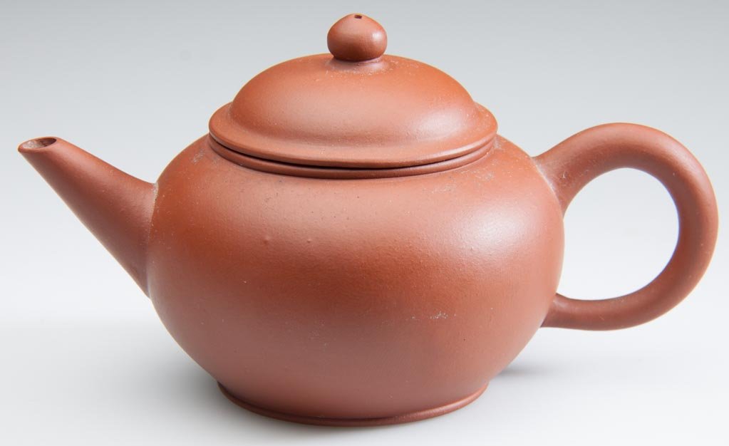 CHINESE YIXING ZISHA CLAY ARTISTIC RED TEAPOT AND COVER: CHINESE YIXING ZISHA CLAY ARTISTIC RED TEAPOT AND COVER, body of squat, globular form, with simple loop handle and straight spout, the domed cover with button-form knop, impressed seal mark to undersi
