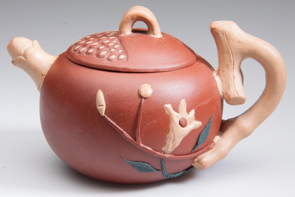 CHINESE YIXING ZISHA CLAY ARTISTIC GLOBULAR TRI-COLOR P: CHINESE YIXING ZISHA CLAY ARTISTIC GLOBULAR TRI-COLOR POMEGRANATE-SHAPE TEAPOT AND COVER, the red body with applied foliate sprigs to the ides, in tan, red and green, the branch-form knop and penile-f