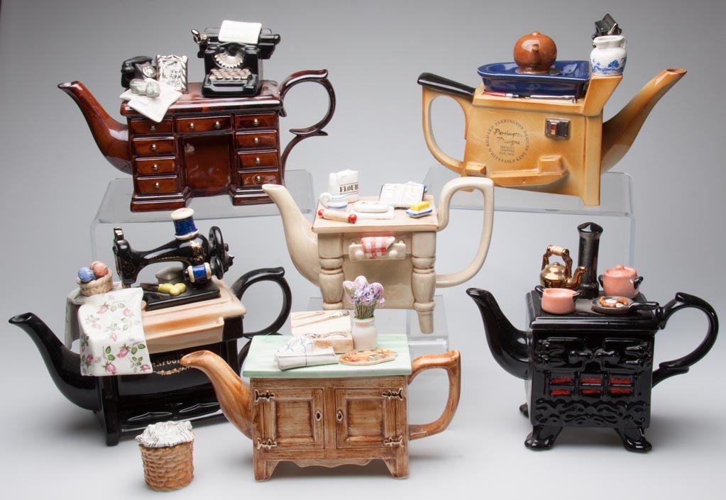 ENGLISH LIMITED EDITION NOVELTY TEAPOTS, LOT OF SIX, BY: ENGLISH LIMITED EDITION NOVELTY TEAPOTS, LOT OF SIX, BY PAUL CARDEW, RICHARD PARRINGTON, AND SWINESIDE CERAMICS, including "Baker's Table," "Infusion Sewing" a model of a stove; "Murder at the Grange,