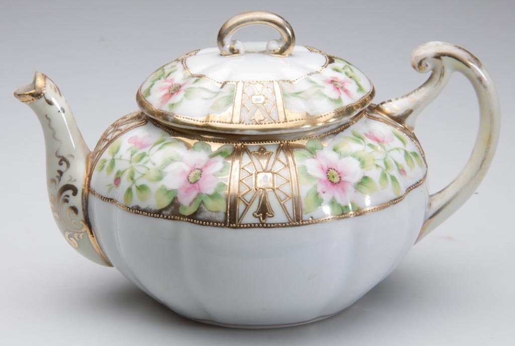 JAPANESE NIPPON PORCELAIN LOBE-MOLDED, SQUAT GLOBULAR T: JAPANESE NIPPON PORCELAIN LOBE-MOLDED, SQUAT GLOBULAR TEAPOT AND COVER, the handle and knop of stylized c-scroll form; the spout with bifurcated lip, the upper body and lower lid painted with bands of