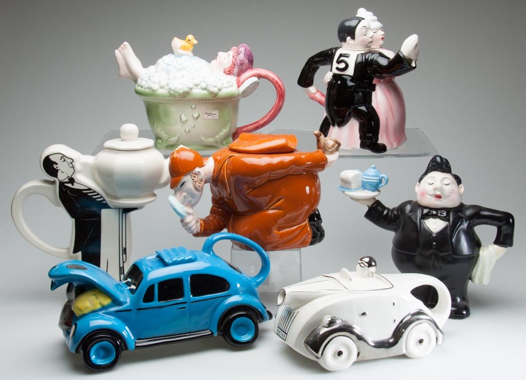 ENGLISH STAFFORDSHIRE POTTERY AND OTHERS, NOVELTY: ENGLISH STAFFORDSHIRE POTTERY AND OTHERS, NOVELTY TEAPOTS, LOT OF SEVEN ARTICLES, including a CRANE flat-formed teapot printed with the image of a 1920s standing butler holding a three-dimensional whi