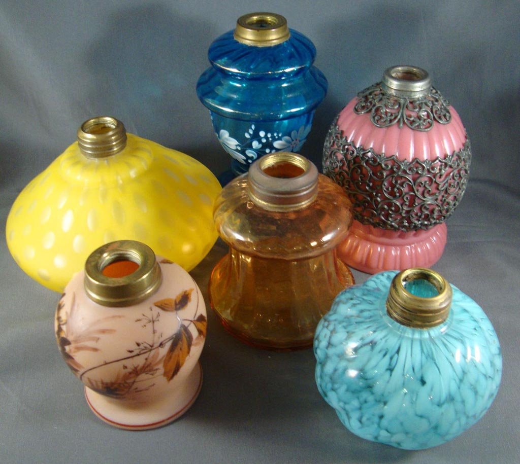 ASSORTED GLASS MINIATURE LAMP BASES, LOT OF SIX: ASSORTED GLASS MINIATURE LAMP BASES, LOT OF SIX, comprising yellow RDMOP, opaque raspberry with filigree, blue transparent, blue opalescent, amberina and fire glow satin. Fourth quarter 19th/early 20t