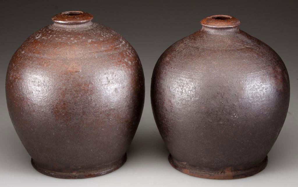 MID-ATLANTIC EARTHENWARE / REDWARE STORAGE JARS, LOT OF: MID-ATLANTIC EARTHENWARE / REDWARE STORAGE JARS, LOT OF TWO, lead glazed, each of graceful ovoid form with small collared mouth and pronounced foot. Found in Pennsylvania. Second half 19th century. 5