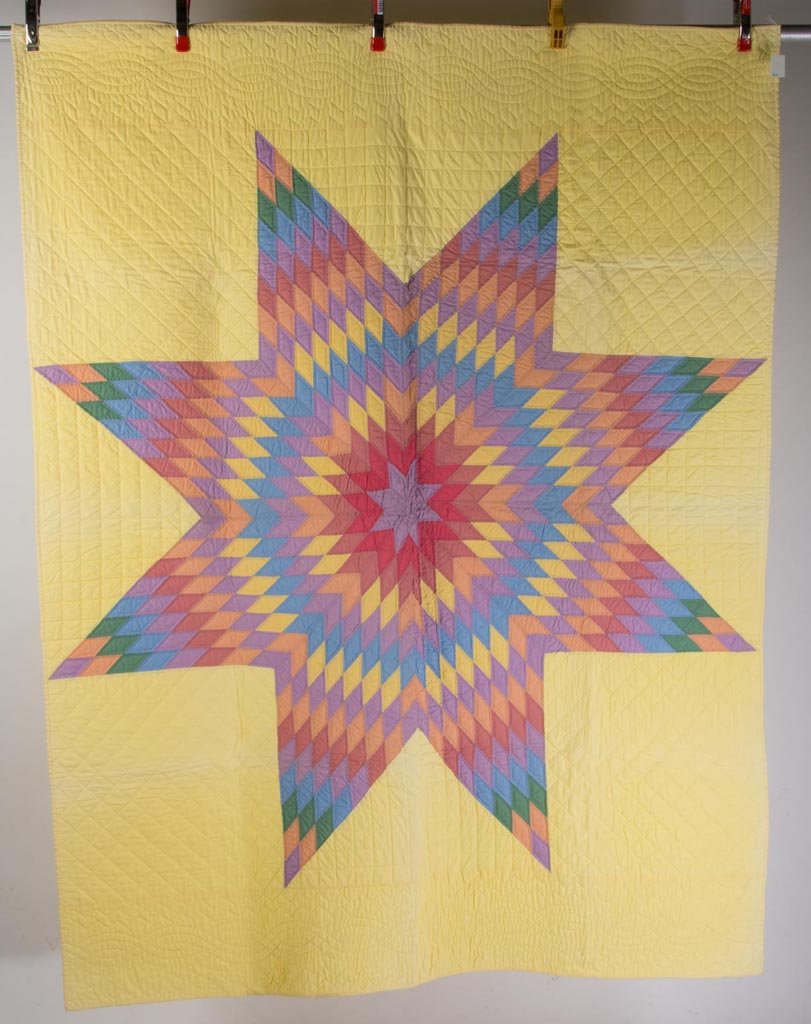 MID-ATLANTIC "TEXAS LONE STAR" PIECED QUILT: MID-ATLANTIC "TEXAS LONE STAR" PIECED QUILT, central pattern comprising 1 1/2" overall length diamonds in multi-colored solids and each outlined with straight-line hand stitching, lemon yellow ground 
