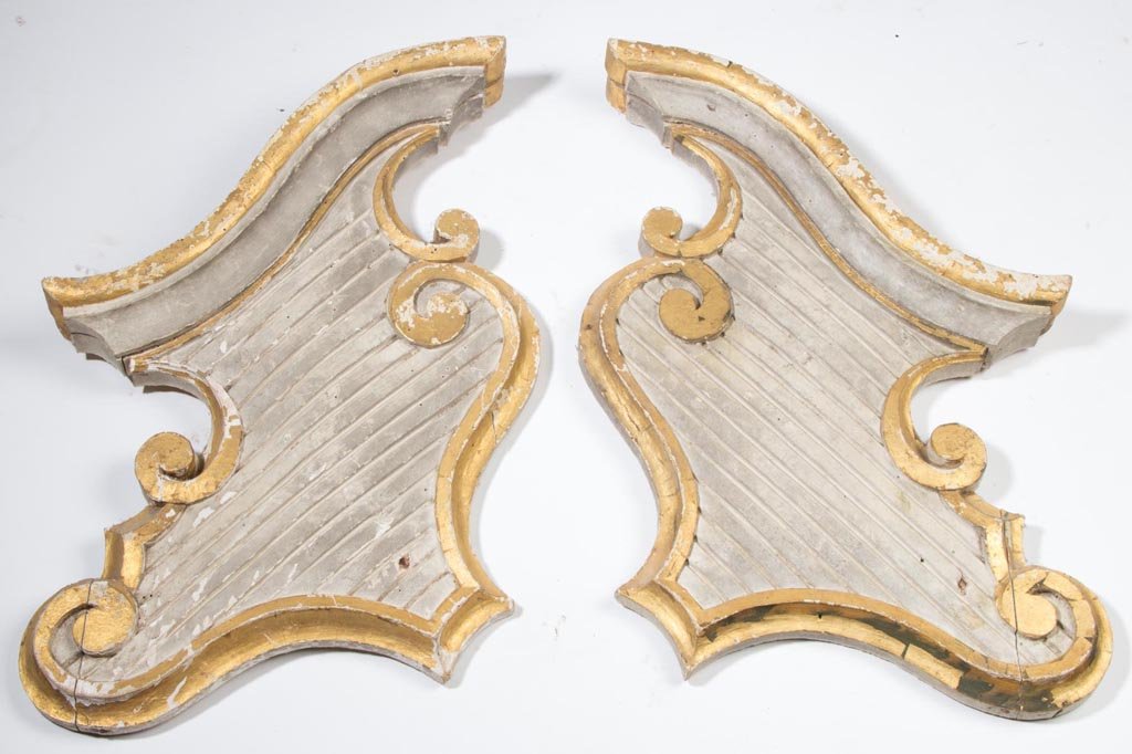 AMERICAN OR EUROPEAN CARVED AND PAINTED WOODEN: AMERICAN OR EUROPEAN CARVED AND PAINTED WOODEN ARCHITECTURAL ELEMENTS, LOT OF TWO, comprising two pediment sections with gilt highlights against a white ground. Late 19th/early 20th century. 15" HOA x
