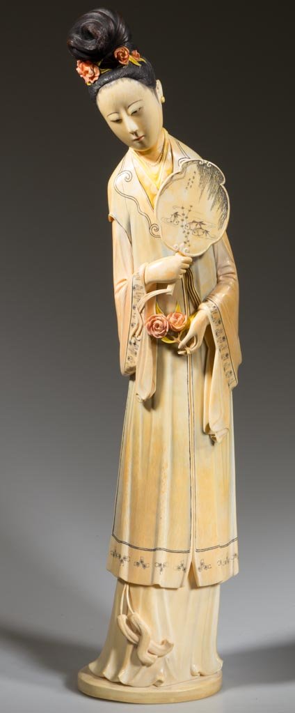 CHINESE CARVED IVORY FEMALE FIGURE: CHINESE CARVED IVORY FEMALE FIGURE, polychrome decoration, carved from a tusk, depicting a finely detailed standing female dressed in a robe and holding a mirror and two roses, inset disc with marking