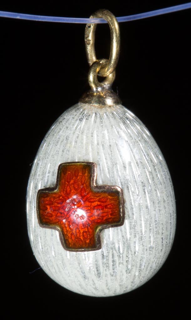 RUSSIAN FABERGE-STYLE GUILLOCHE GOLD MINIATURE EGG: RUSSIAN FABERGE-STYLE GUILLOCHE GOLD MINIATURE EGG PENDENT, with an applied red cross, maker's mark on hanging ring, no other markings located. Weight: 2.7 dwt. 20th century. 3/4" H, 1/2" D. Provenanc