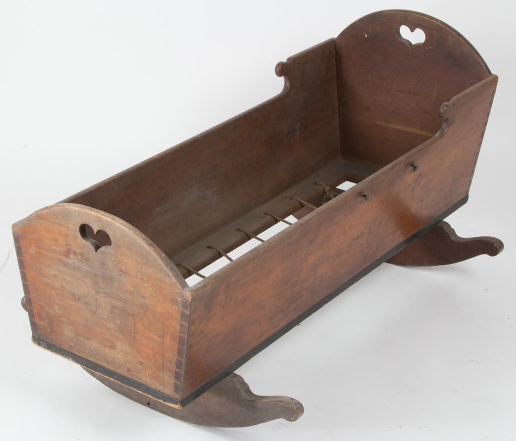 PENNSYLVANIA CHERRY CRADLE: PENNSYLVANIA CHERRY CRADLE, dovetailed case with cut-out sides and hearts in the ends, framed bottom with rope holes, raised on cut-out cheese-cutter rockers joined to the frame with rosehead nails. E