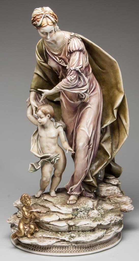 ITALIAN PORCELAIN A MADONNA AND CHILD FIGURE: ITALIAN PORCELAIN A MADONNA AND CHILD FIGURE, standing on a rocky mount, with a gilt putto holding a tablet in the foreground, based on an El Grecco painting, marked in red A. Bovaso, Made in Italy an
