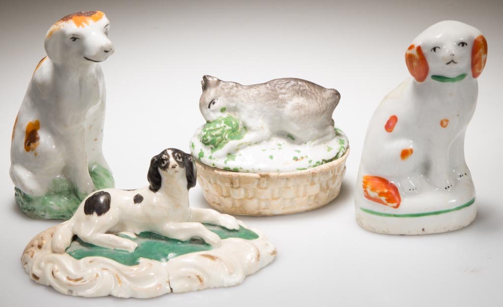ENGLISH STAFFORDSHIRE AND JAPANESE PORCELAIN SMALL: ENGLISH STAFFORDSHIRE AND JAPANESE PORCELAIN SMALL FIGURES OF ANIMALS, LOT OF FOUR, including a seated hound; a seated spaniel, a King Charles spaniel lying on a green mounded, gilt-enhanced scrolling