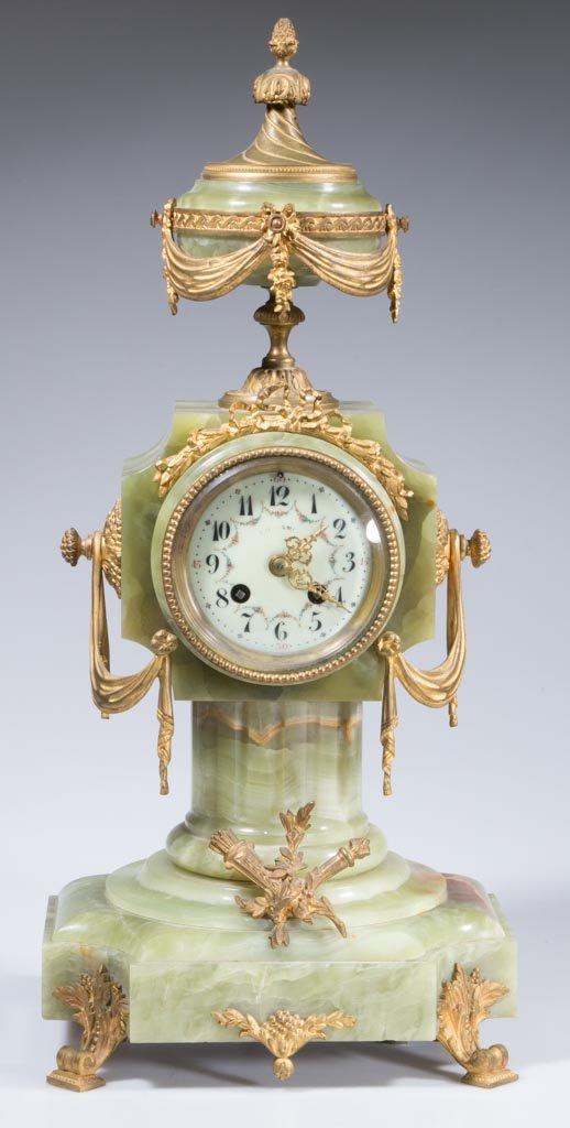 FRENCH NEOCLASSICAL ONYX AND GILT-BRONZE SHELF CLOCK: FRENCH NEOCLASSICAL ONYX AND GILT-BRONZE SHELF CLOCK, surmounted with an urn-form finial, raised on four scrolled feet, porcelain dial, movement markings include DA Mougin. With pendulum and key. Four