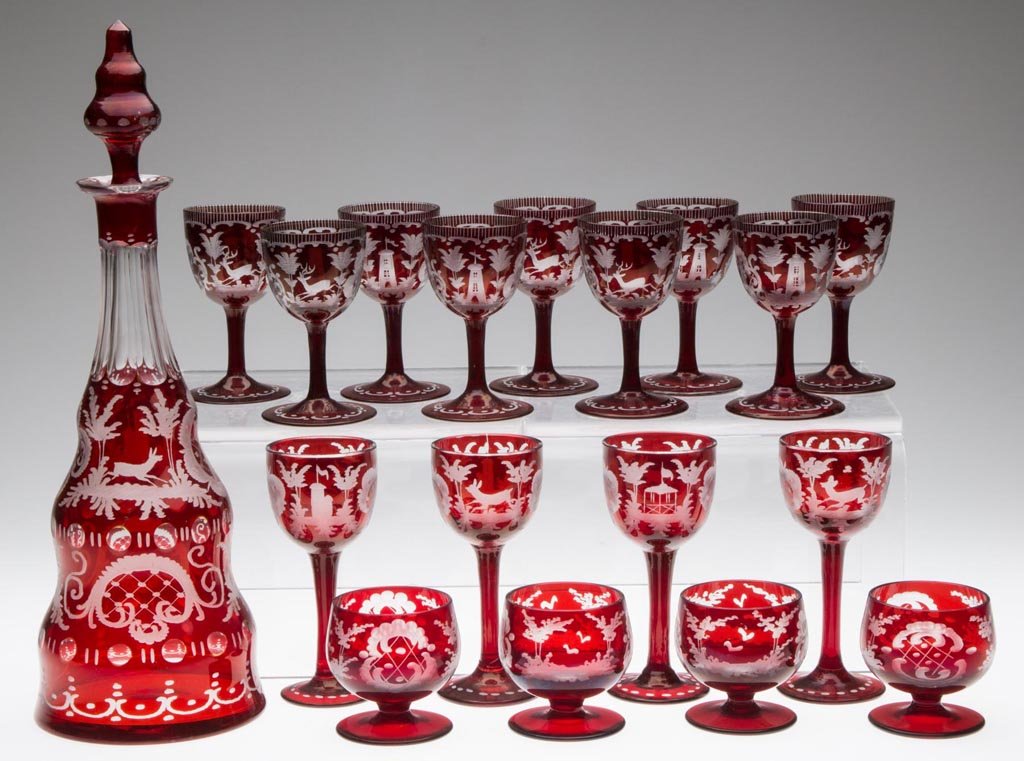 BOHEMIAN ENGRAVED DRINKING VESSELS, LOT OF 18: BOHEMIAN ENGRAVED DRINKING VESSELS, LOT OF 18, ruby-stained colorless, comprising a decanter with four wines, set of nine cordials, and set of four liquor glasses, various stag, castle and related dec