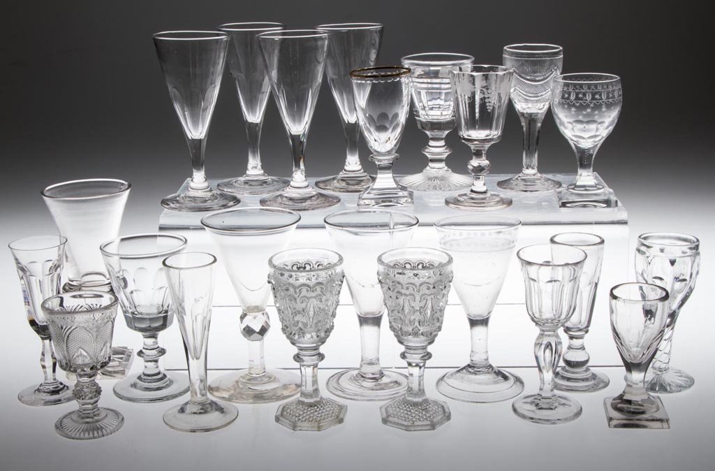 ASSORTED EARLY CORDIALS / WINE GLASSES, LOT OF 23: ASSORTED EARLY CORDIALS / WINE GLASSES, LOT OF 23, colorless, including free-blown, engraved, cut, and pressed lacy, two with folded foot and rough pontil mark, most of remainder with polished pontil 