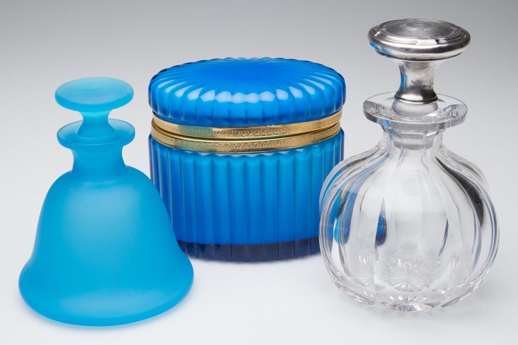 ASSORTED GLASS DRESSER ARTICLES, LOT OF THREE: ASSORTED GLASS DRESSER ARTICLES, LOT OF THREE, comprising a blue cased jewel box with Murano Glass label under base, a panel-cut cologne bottle with Wallace sterling silver stopper, and a blue satin p