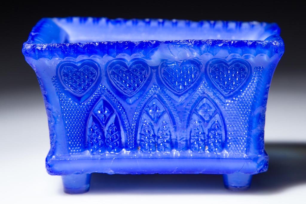 GA-4 VARIANT GOTHIC ARCH AND HEART PRESSED OPEN SALT: GA-4 VARIANT GOTHIC ARCH AND HEART PRESSED OPEN SALT, opalescent medium blue, even scallop rim, on four bucket feet. Base like GA-4a. Rare. Possibly Boston & Sandwich Glass Co. 1835-1845. 1 3/4" H, 2"